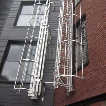 Echelle coulissante - Perpendiculaire au mur avec une crinoline - Evacuation incendie Echelle coulissante perpendiculaire au mur avec une cage de protection (crinoline) et utilisée pour l'évacuation incendie.